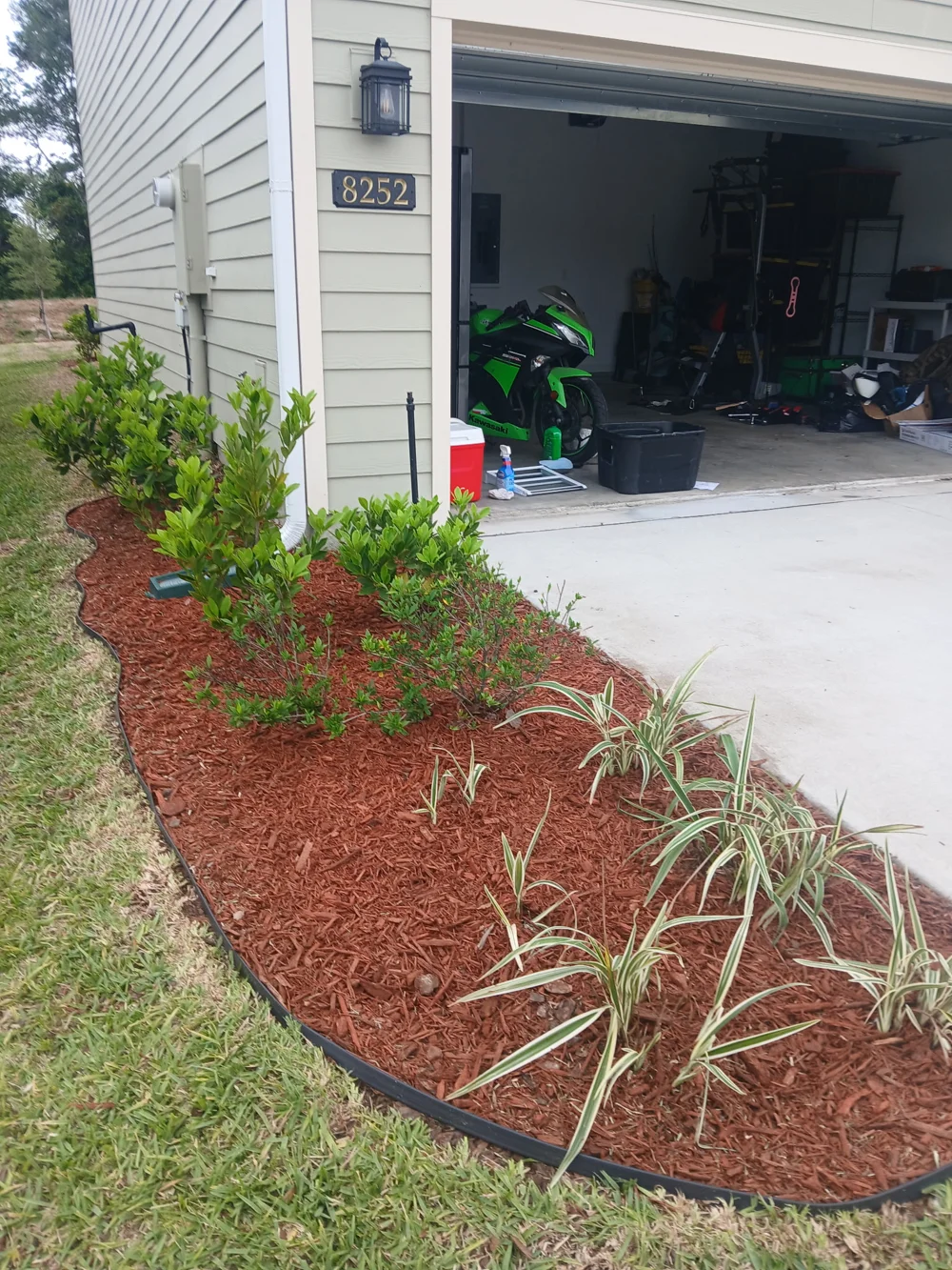 After lawn and landscape bed care: defined beds beside the garage